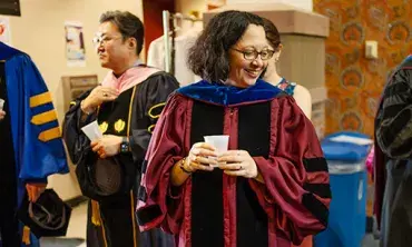 Stacie Raucci, the Frank Bailey Professor of Classics and chair of the department, mingles with colleagues in the lobby of Yulman Theater as they prepared to robe before Convocation. Raucci is the new College Marshal.
