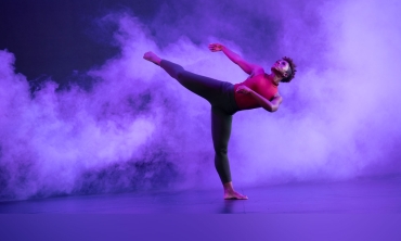 A Dayton Contemporary Dancer extending his legs and one arm