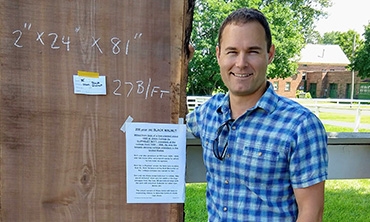  Jeff Jauregui proudly poses with his prized purchase of a 200-year-old walnut slab.