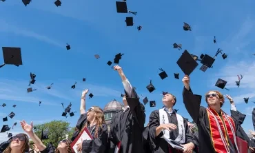 Students fling their caps into the air