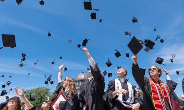 Students fling their caps into the air