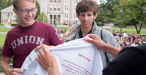 Students receiving shirts with the lyrics of Ode to Old Union printed on them.