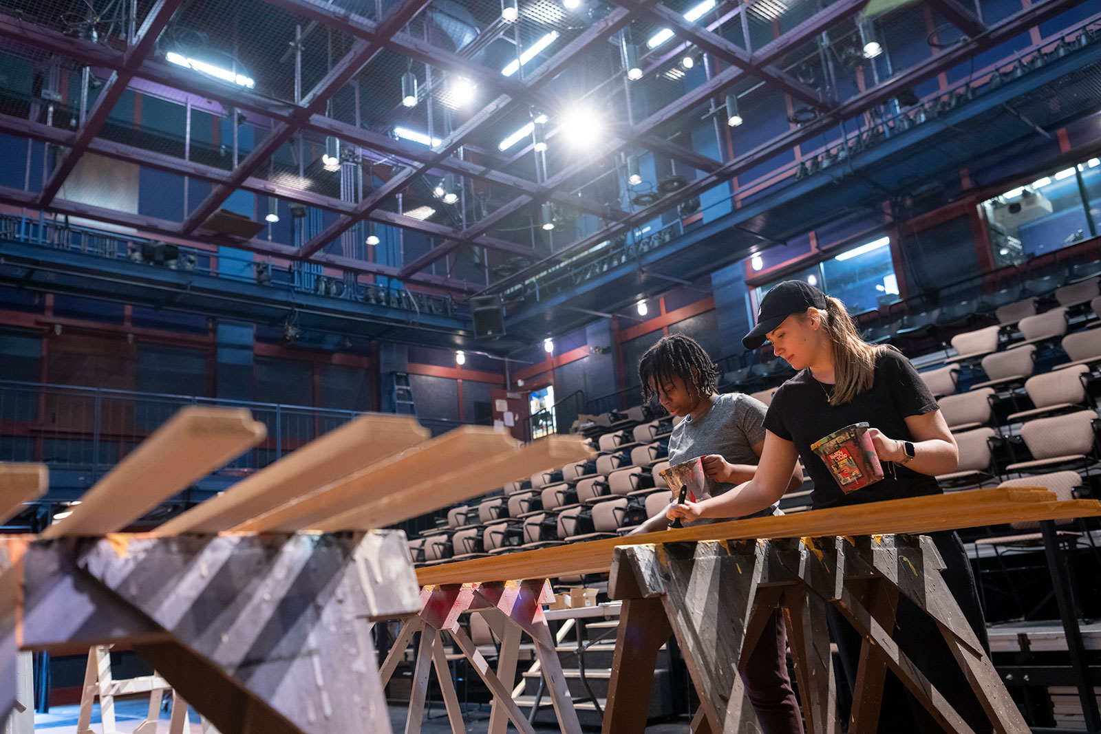 Two students painting stage components on the Yulman Theater stage.