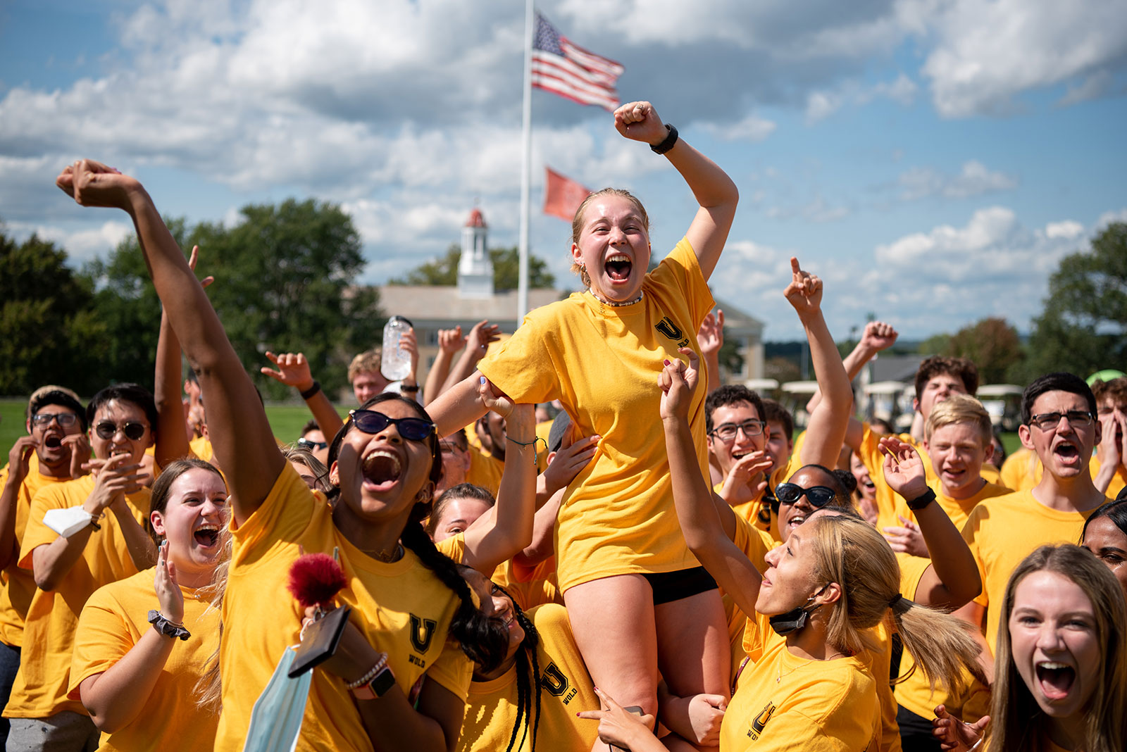 Students on the yellow team enthusiastically leap up during the Minerva Olympics.