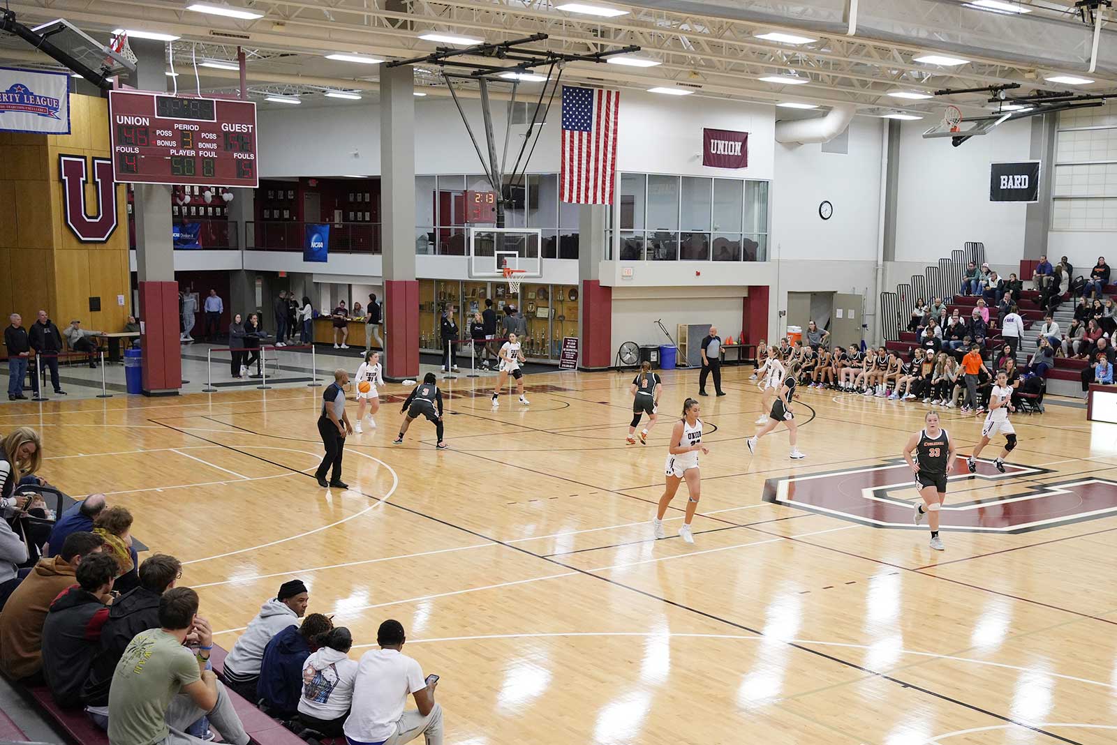 A scene from a women's basketball game featuring Union team players sprinting down the parquet floor.