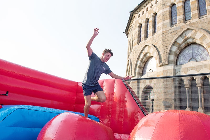 A student jumps up and down on an inflatable bouncing ball during Student Expo